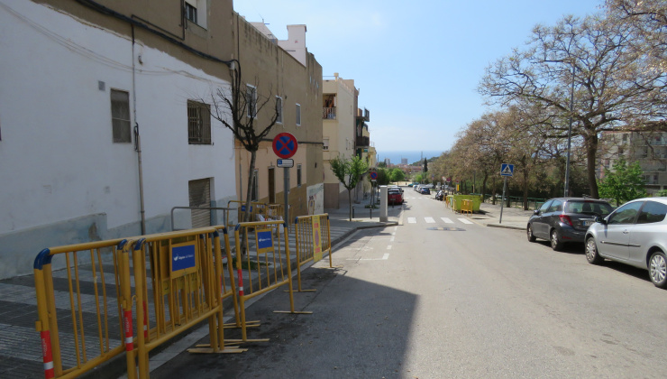 Carrer de la Immacxulada amb tanques d'obres color groc a la dreta
